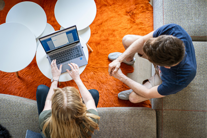 Leuchter IT culture: Two employees work collaboratively on a laptop in a modern lounge 